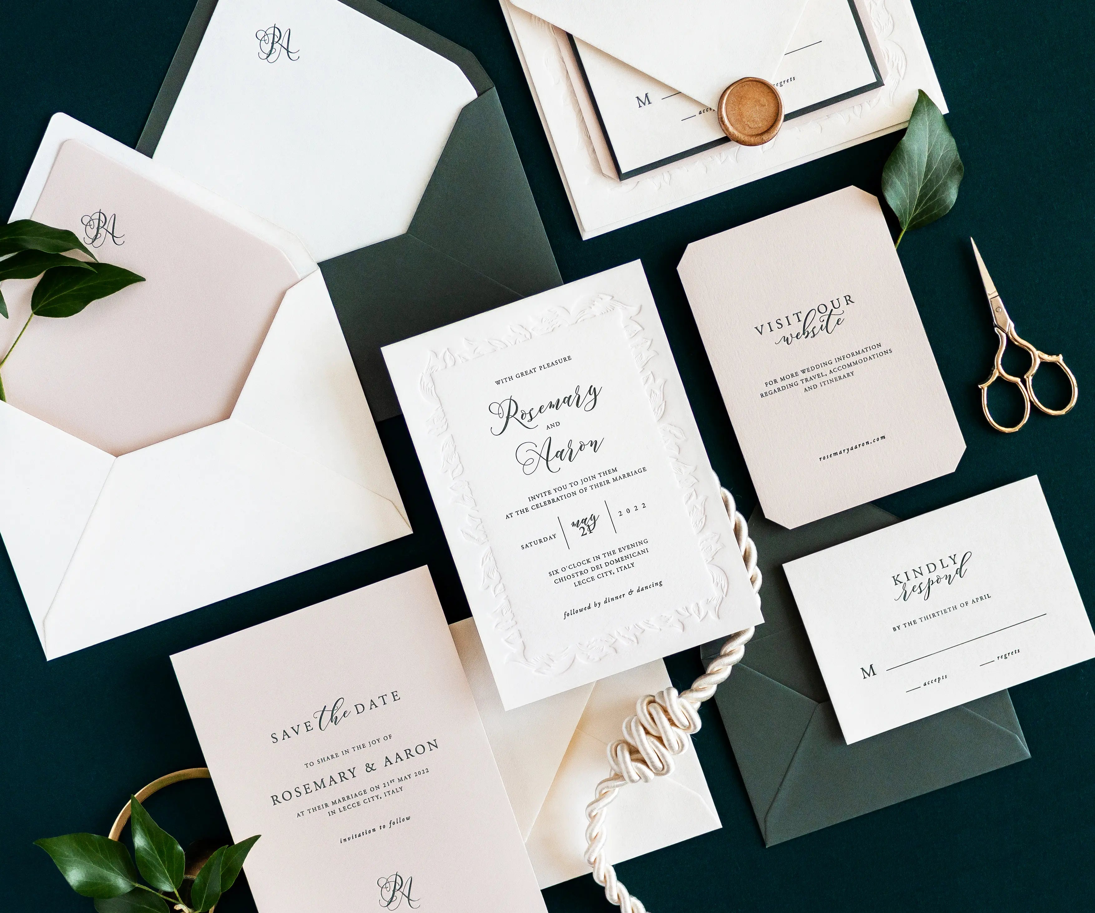 Angled top view of acanthus themed letterpress wedding invitation set and envelopes