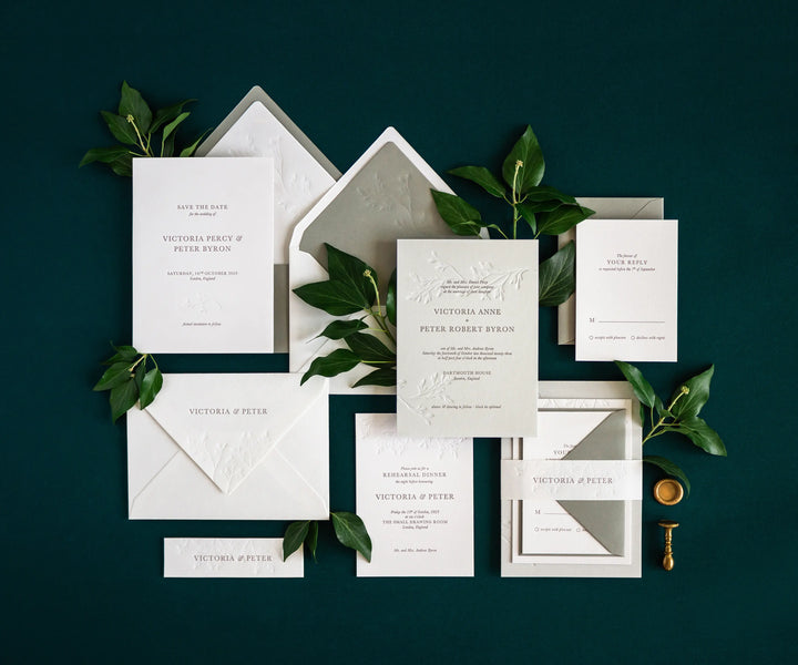 Top view of ivy themed letterpress wedding invitation set and envelopes