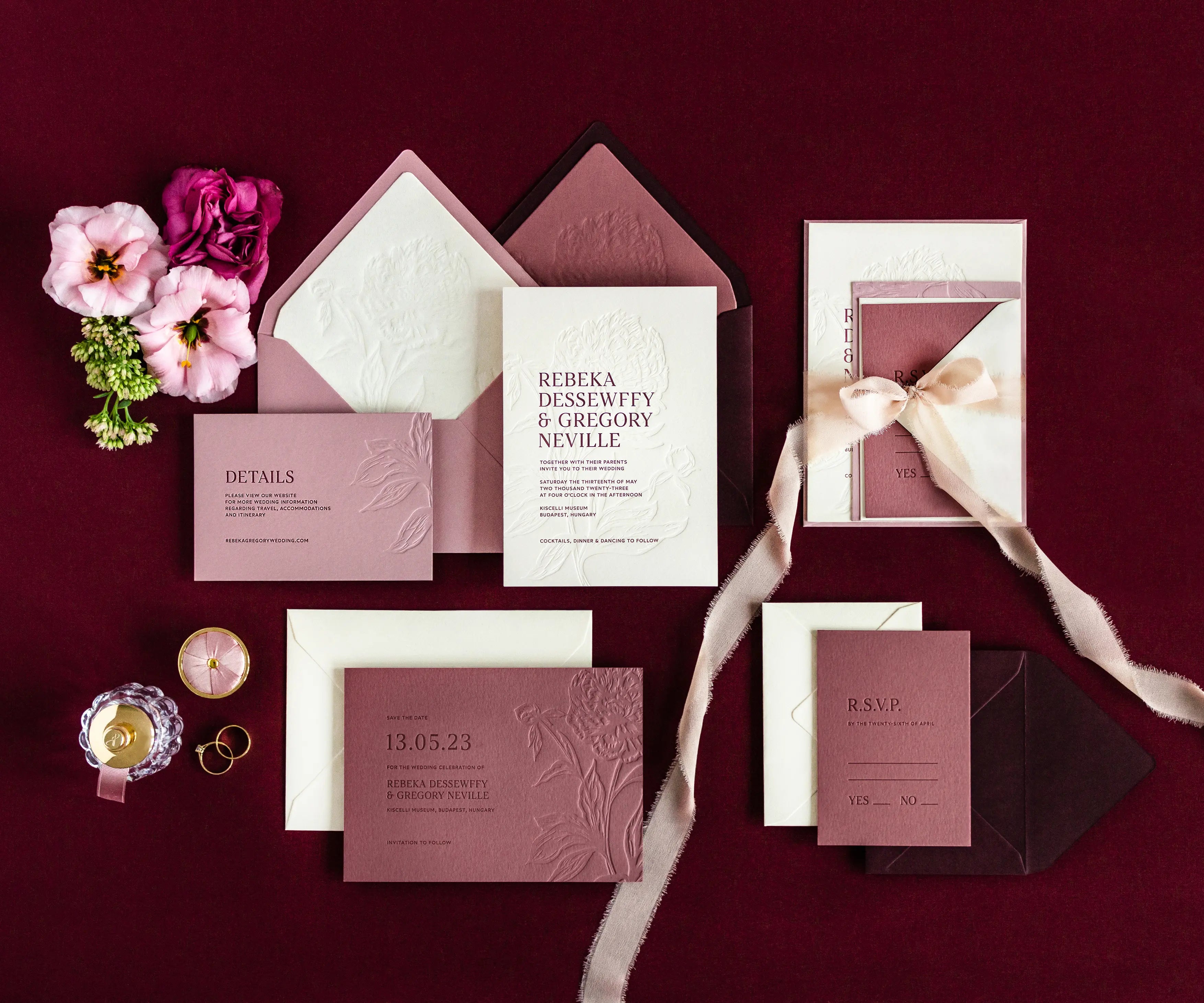 Top view of peony themed letterpress wedding invitation set and envelopes