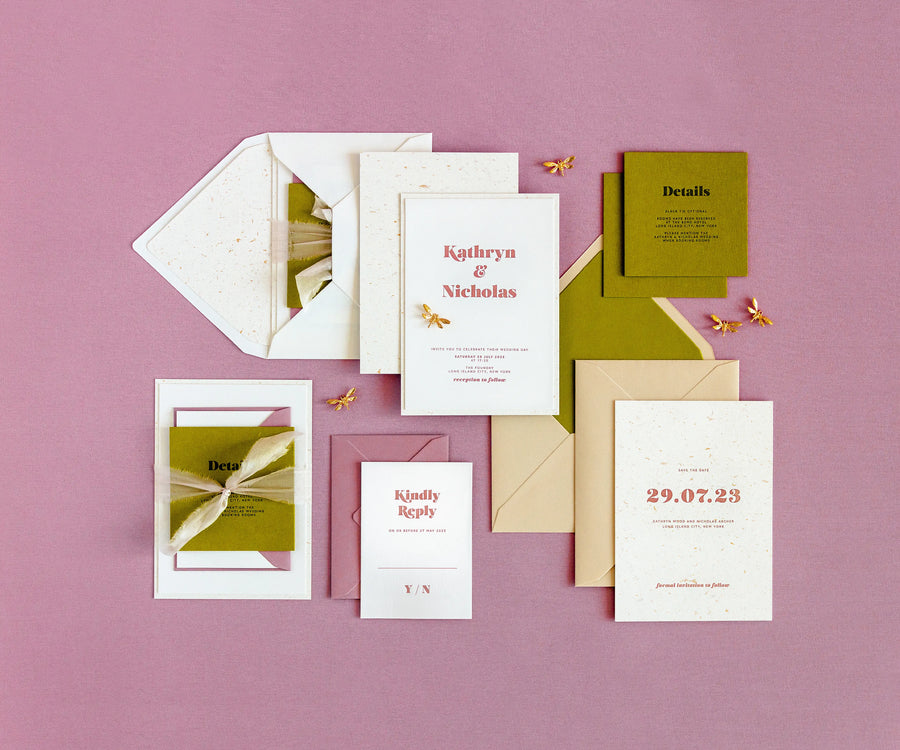 Top view of sunrise themed letterpress wedding invitation set and envelopes