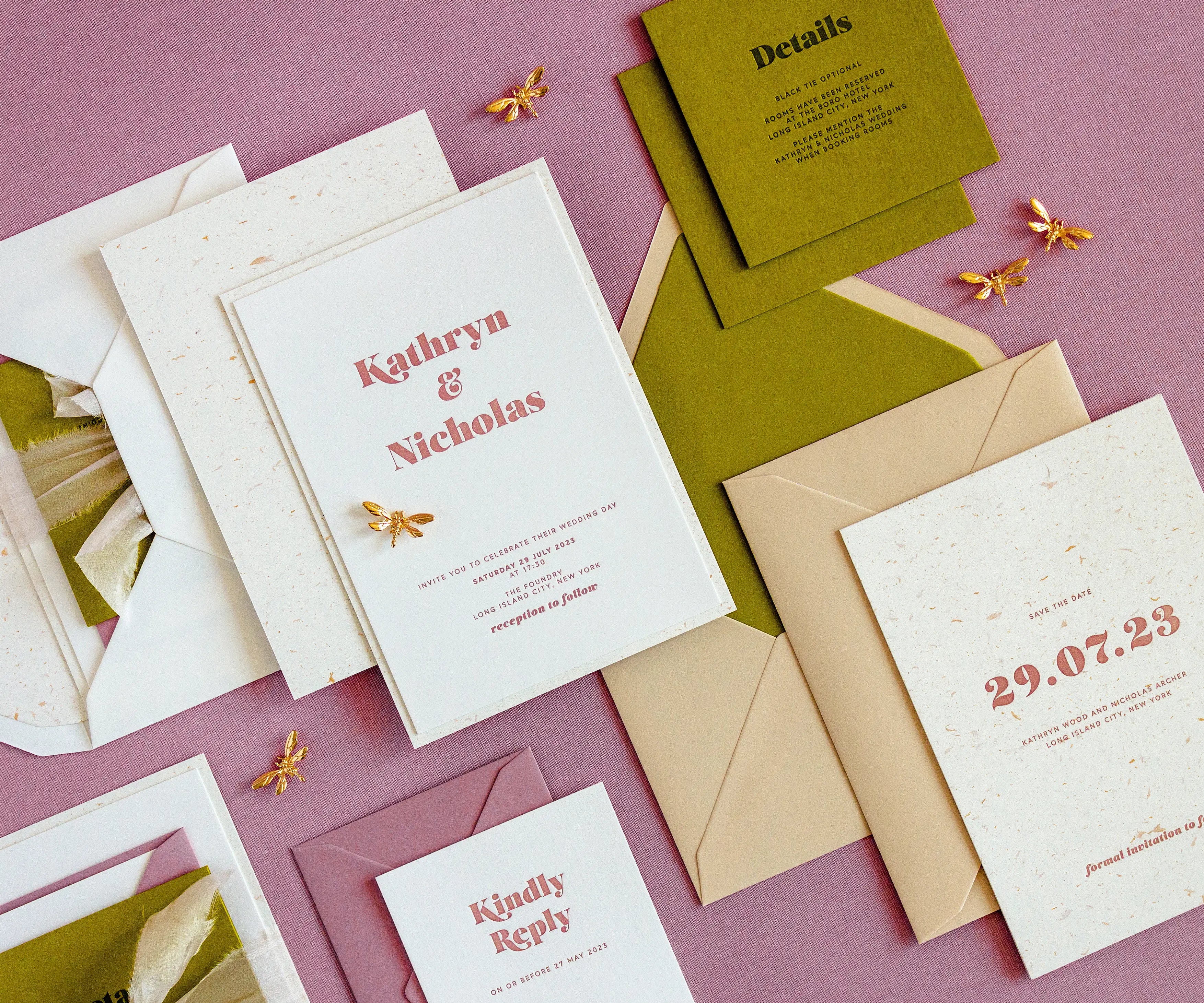 Angled top view of sunrise themed letterpress wedding invitation set and envelopes