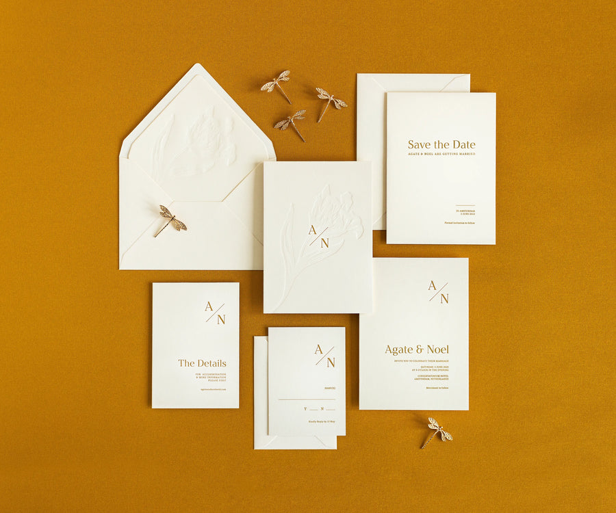 Top view of tulip themed letterpress wedding invitation set and envelopes